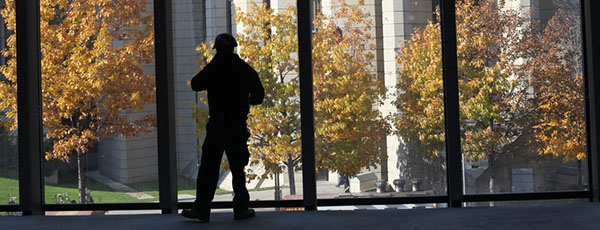 Photo of student silhouetted against fall foliage