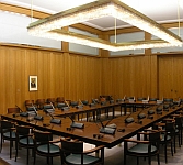 An office board room with dozens of chairs around a huge oak table