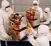 four laboratory technicians in labcoats working on a motor